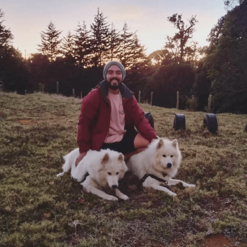 Hombre feliz en la montaña con 2 perros somayedo color blanco